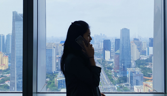 A woman in an office overlooking a city. Human resource planning